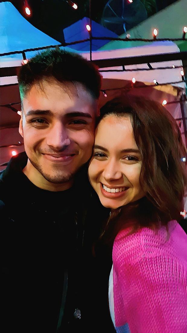 Selfie nossa sorrindo sob luzinhas coloridas